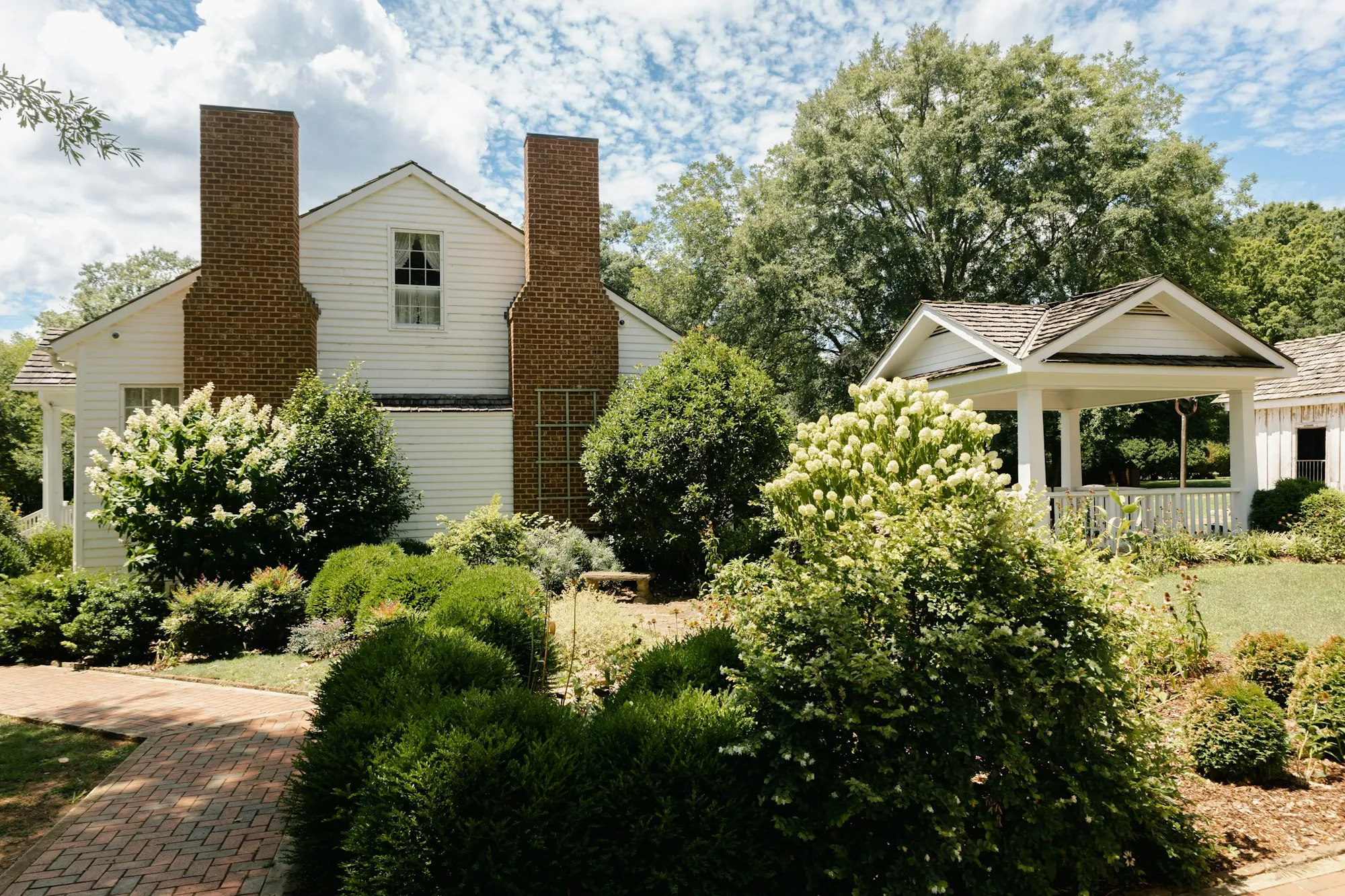 White house with a garden path and blooming shrubs